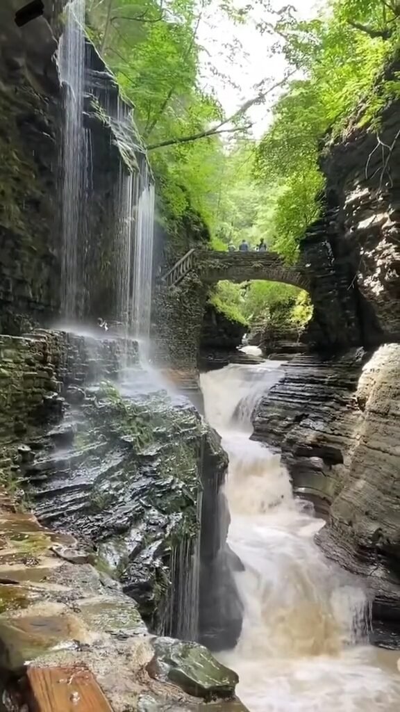 Watkins Glen State Park, featuring stone bridges and staircases along a gorge with multiple waterfalls.